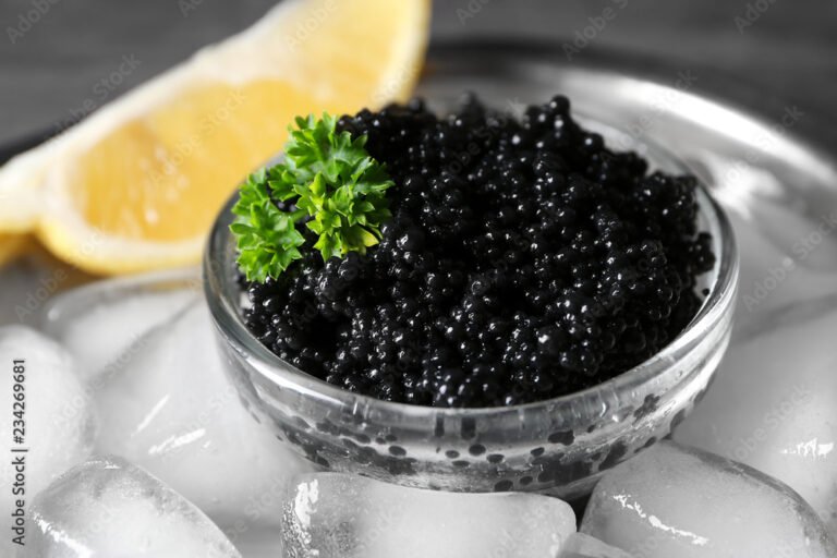 Bowl with delicious black caviar and ice-cubes, closeup